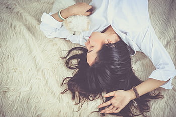 A woman peacefully sleeping with her pet dog on a soft, furry rug indoors. HD wallpaper