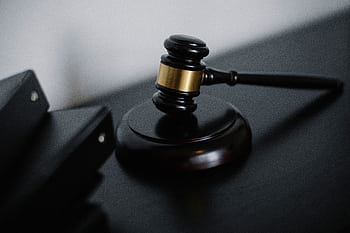 Close-up of a wooden gavel on a desk, symbolizing justice and legal authority. HD wallpaper