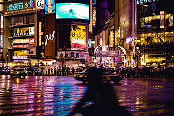 Experience the vibrant nightlife at Shibuya Crossing, Tokyo with neon lights and bustling crowd. HD wallpaper