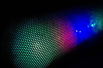 Vivid abstract of colorful LED lights through a speaker grille, showcasing vibrant technology design. HD wallpaper