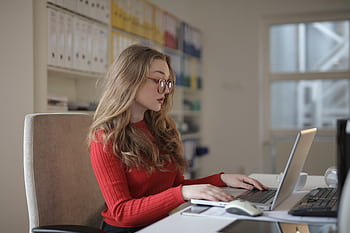 A dedicated female lancer working on a laptop from her home office. HD wallpaper