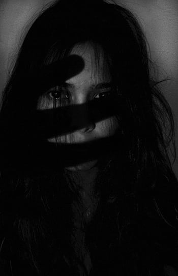 A dramatic black and white portrait of a woman with shadows cast across her face, creating a mysterious and eerie mood. HD phone wallpaper