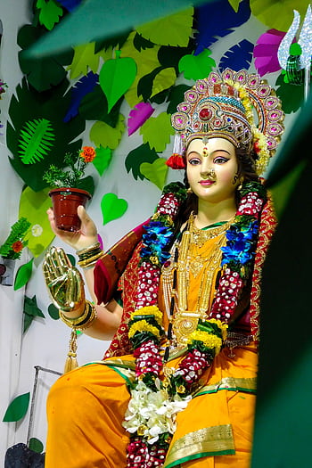 Vibrant depiction of Hindu Goddess Durga in a festive setting with floral decorations. HD phone wallpaper