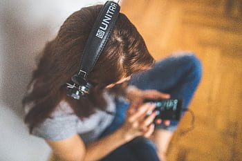 Top view of a woman using a smart and listening to music with heads. HD wallpaper
