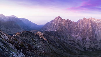 Stunning view of a rocky mountain range during sunrise with a colorful sky. HD wallpaper
