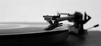 Black and white of a record player needle on a spinning vinyl, highlighting classic music technology. HD wallpaper