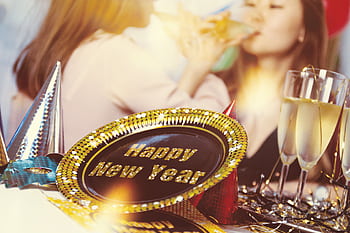 Cheerful New Year party scene with champagne glasses and sparkling decorations. HD wallpaper