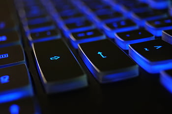 Detailed of a computer keyboard with blue LED backlighting, highlighting keys. HD wallpaper