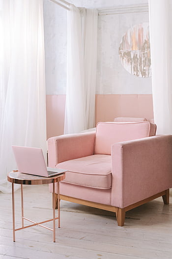 A chic pink armchair in a bright, modern living room with a laptop on the side table. HD phone wallpaper