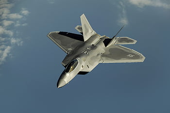 Powerful military aircraft soaring against a calm blue sky. HD wallpaper