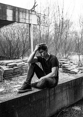 A man sits alone, deep in thought, in a monochrome urban setting. HD phone wallpaper