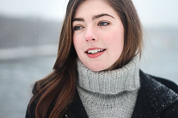 Close-up portrait of a young woman smiling outdoors in the snowy winter. HD wallpaper