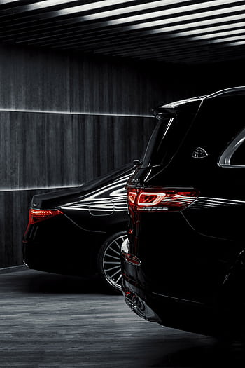 Sleek black luxury cars parked indoors with elegant lighting creating a dramatic effect. HD phone wallpaper