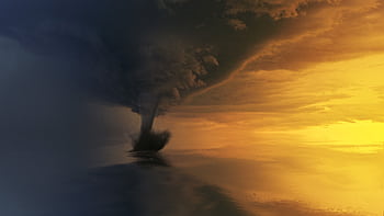 A powerful tornado over the ocean during a dramatic sunset, capturing the storm's intensity and beauty. HD wallpaper