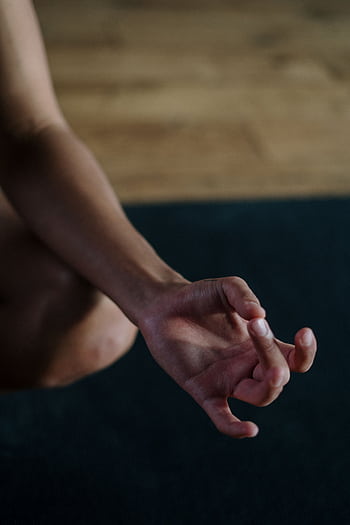 A close-up view of a hand in a yoga mudra position, symbolizing relaxation and focus. HD phone wallpaper