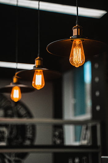 Close-up of warm glowing Edison bulbs hanging from the ceiling indoors. HD phone wallpaper