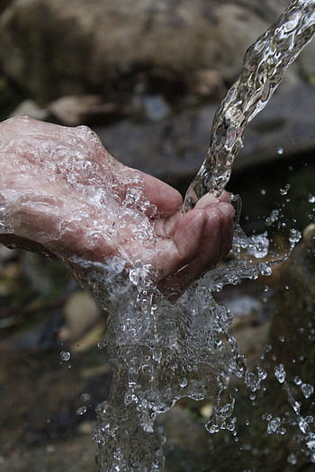 Close-up of a human hand under a stream of clear, flowing water. HD phone wallpaper