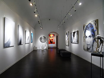 Sleek and modern art gallery with various contemporary paintings on display. HD wallpaper