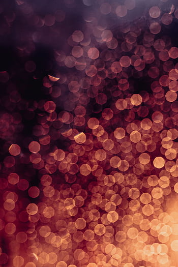Abstract bokeh lights in red and orange create a warm, festive atmosphere. HD phone wallpaper