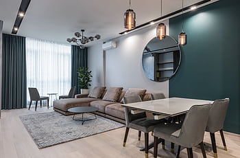 Elegant contemporary living area with stylish furniture, mirror, and ambient lighting. HD wallpaper