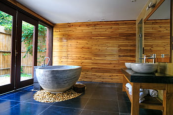Elegant bathroom showcasing a modern marble tub and wooden interior for a serene escape. HD wallpaper