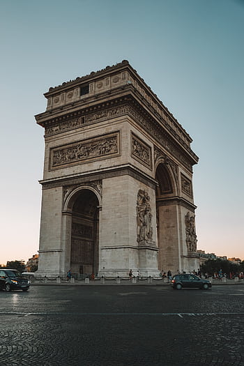 A stunning view of the Arc de Triomphe in Paris captured during the golden hour, highlighting its architectural beauty. HD phone wallpaper
