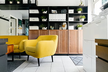Stylish modern living room interior with a yellow armchair and wooden storage units. HD wallpaper