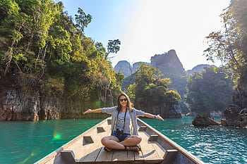 Asian woman relishing a serene boat journey through the lush karst landscape of Thailand's Khlong Sok. HD wallpaper