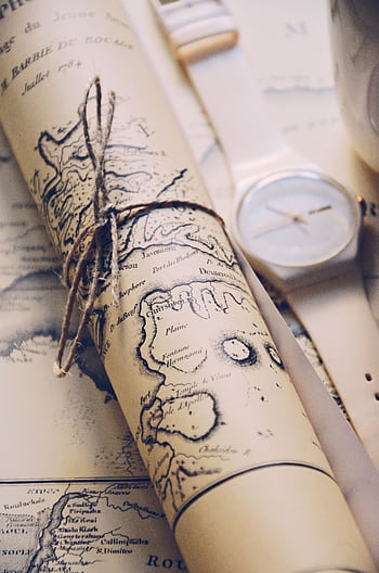 Close-up of a rolled vintage map tied with string, accompanied by a wristwatch. HD phone wallpaper