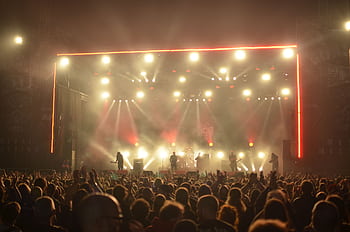 Dynamic live concert with band on stage, lighting effects, and enthusiastic crowd at night. HD wallpaper