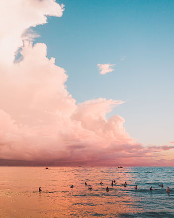 A stunning Hawaiian sunset with surfers on the ocean, capturing vibrant colors and serene waves. HD phone wallpaper