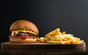 Delicious cheeseburger with ketchup and fries on a wooden board. HD wallpaper