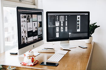 A well-organized design workspace with dual monitors and design software on display. HD wallpaper