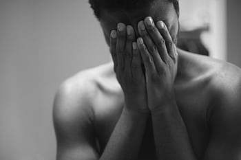 Black and white portrait of a man in distress, conveying deep emotions and vulnerability. HD wallpaper