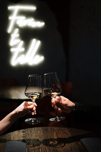 Two people clinking wine glasses in a warmly lit restaurant, creating a romantic ambiance. HD phone wallpaper