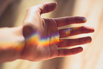 A hand with a beautiful rainbow light refraction across the palm. HD wallpaper