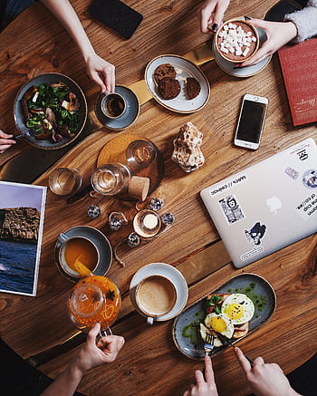 A group enjoying a diverse brunch spread with coffee on a rustic wooden table. Perfect for food and lifestyle themes. HD phone wallpaper