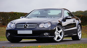 Shiny black Mercedes convertible on an outdoor road in daylight, showcasing luxury and design. HD wallpaper