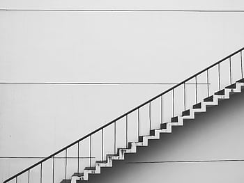 Minimalistic black and white staircase with sharp angles and clean lines, showcasing modern architecture. HD wallpaper