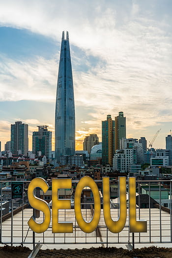 Stunning view of Lotte Tower and Seoul's skyline during sunset, highlighting the city's urban architecture. HD phone wallpaper