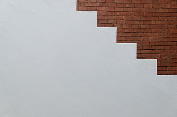 Abstract of a brick and concrete wall forming a staircase shape, ideal for contemporary design themes. HD wallpaper