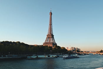 Scenic view of the Eiffel Tower and Seine River at sunset, showcasing iconic Parisian architecture. HD wallpaper