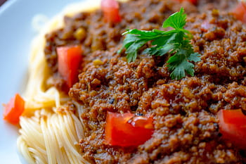 Close-up of a tasty spaghetti Bolognese topped with fresh parsley and tomatoes. HD wallpaper