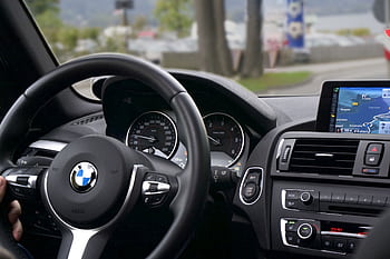 Elegant BMW car interior showcasing navigation screen, speedometer, and steering wheel. HD wallpaper