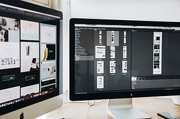 A modern workspace featuring dual computer monitors displaying web design projects, emphasizing technology and productivity. HD wallpaper