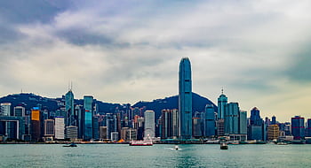 Stunning view of Hong Kong's skyline from Kowloon at sunset, featuring modern skyscrapers. HD wallpaper