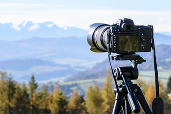 DSLR camera on tripod capturing a stunning mountain view on a clear day. HD wallpaper