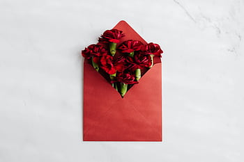 Elegant red roses in an envelope on a marble surface, perfect for Valentine's Day. HD wallpaper