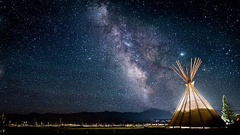 A mesmerizing view of the Milky Way over a teepee under a starry night sky, perfect for astronomy lovers. HD wallpaper
