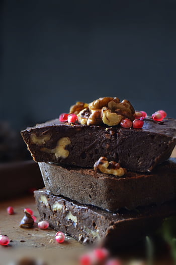 Delicious stacked chocolate brownies topped with walnuts and berries for a rich dessert experience. HD phone wallpaper